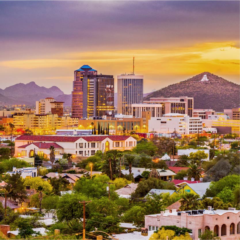 The city of Phoenix in the evening with hills and a sunset in the background.